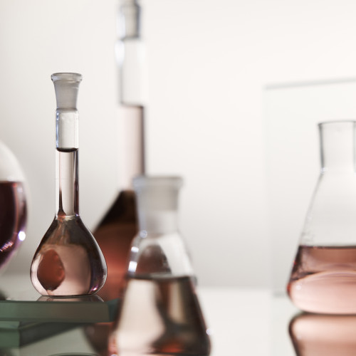 laboratory-glassware-with-pink-liquid-arrangement
													                