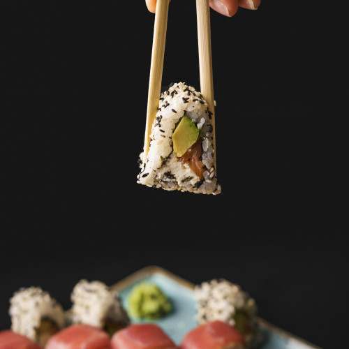 person-holding-sushi-with-chopsticks
                                        